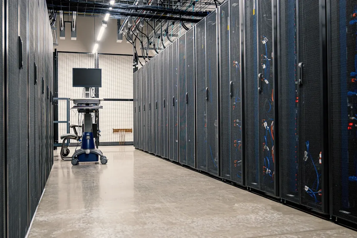 A data centre corridor lined with server racks and structured network cabling on both sides